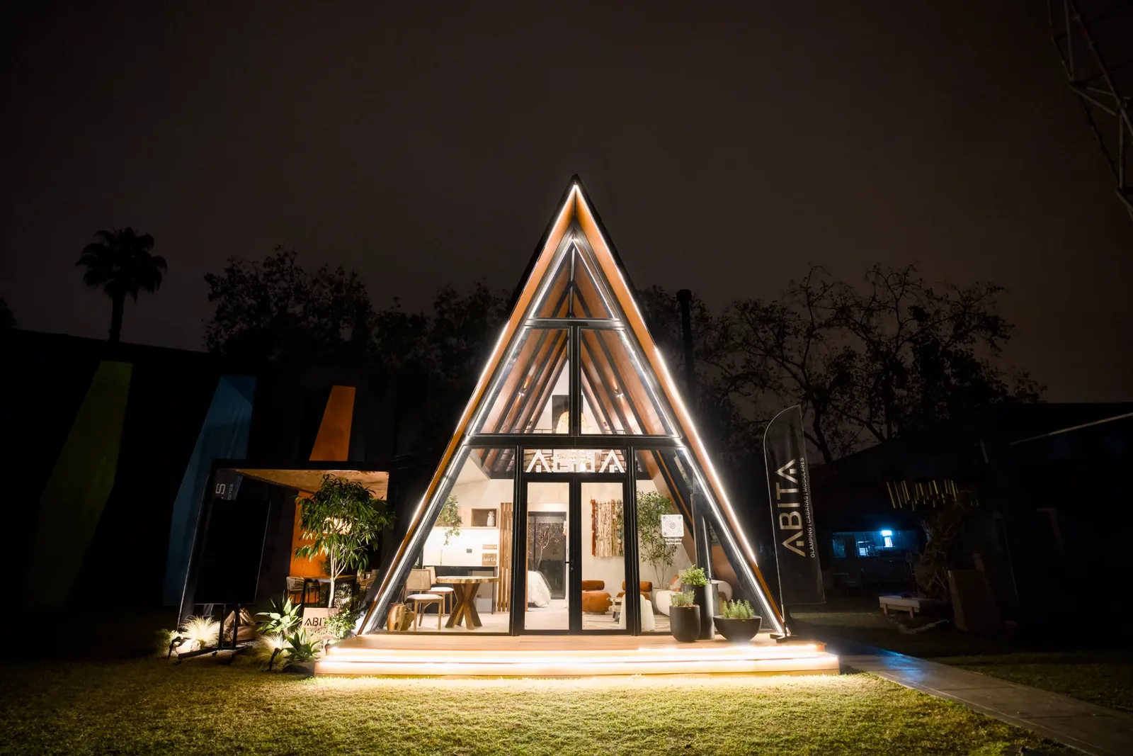 Qhapaq 1 de noche: fachada de cristal iluminada en la unidad presentada por ABITA