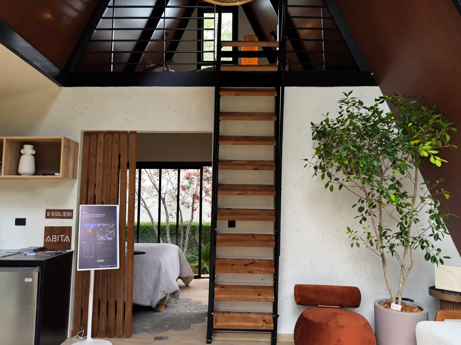 Sala a doble altura de la Qhapaq 1 con la escalera al mezzanine instalada, en la unidad presentada por ABITA